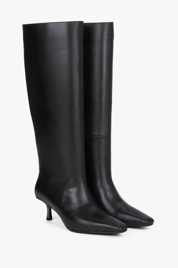 Dark brown women’s knee-high boots with an elastic shaft on a low funnel heel.