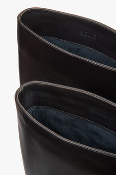 With an elastic shaft, dark brown women’s knee-high boots on a low funnel heel Estro.