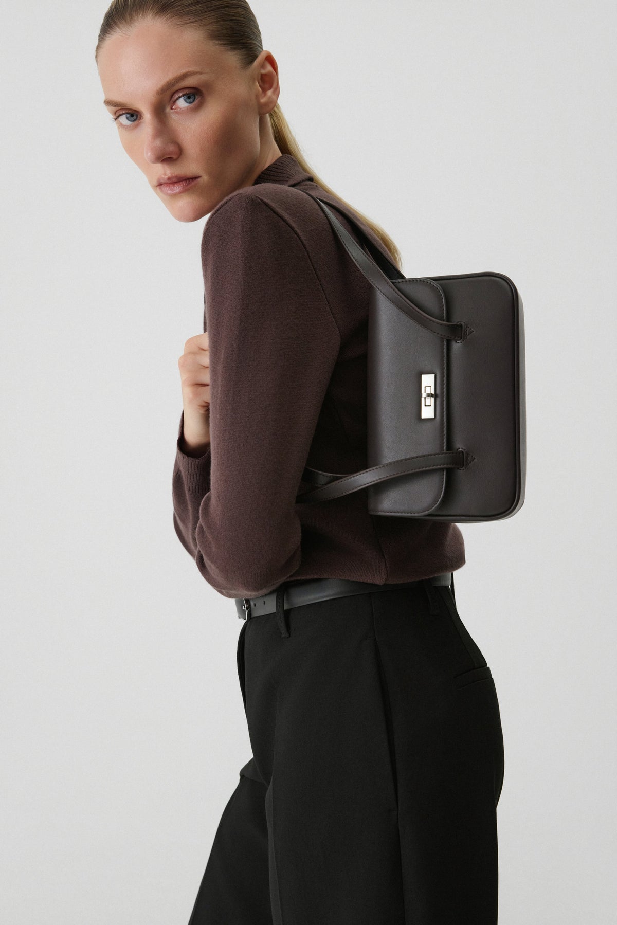Dark brown leather women's shoulder bag with extended handles and silver-tone hardware, Estro.
