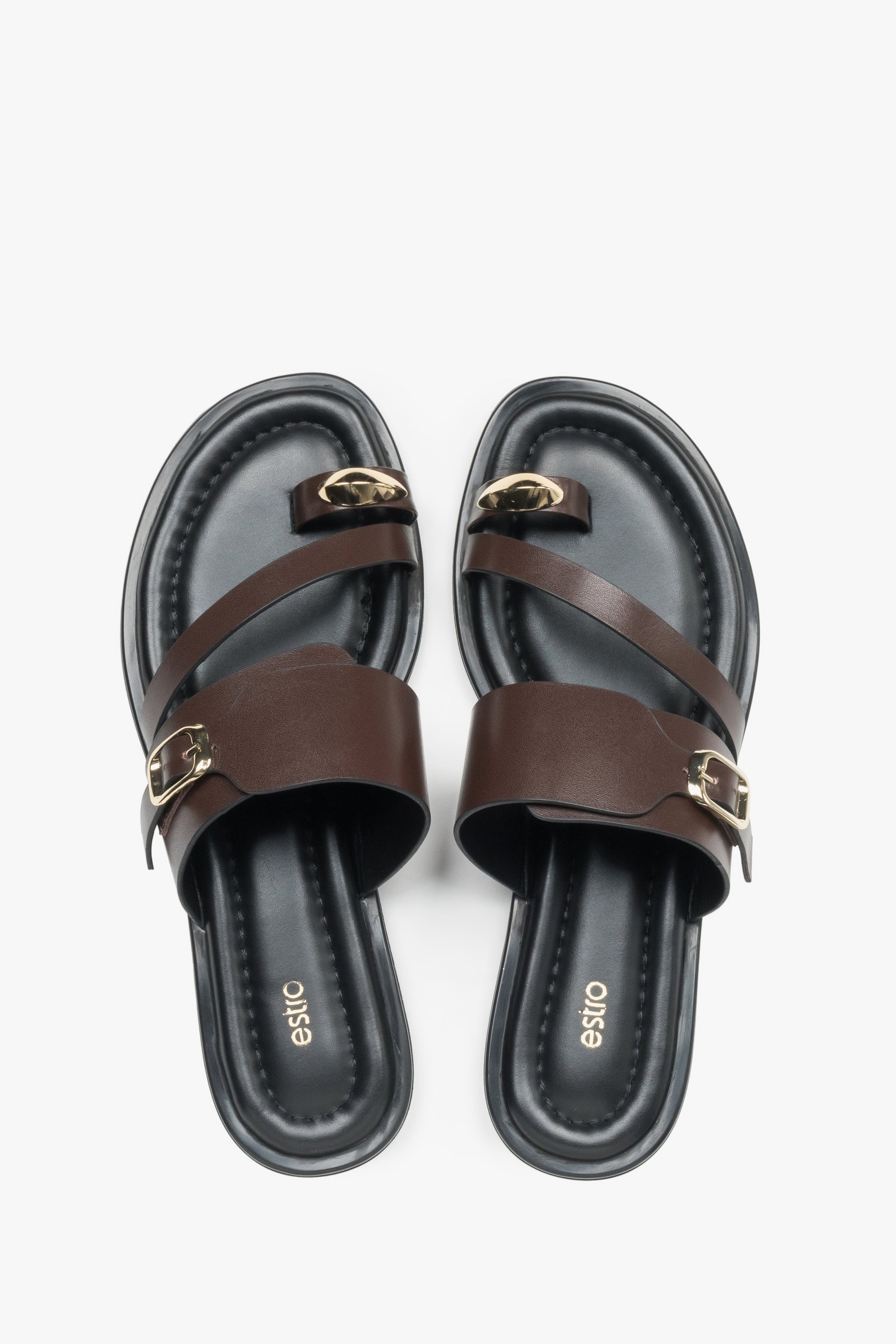 Top view of a pair of shoes showcasing a wide criss-cross strap design, a toe loop for the big toe, and a dark insole featuring the brand logo.
