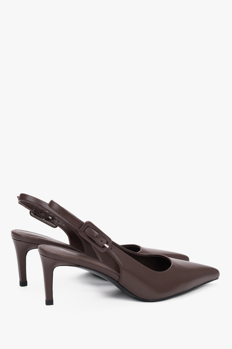 Close-up of the pointed toe and silver-tone buckle on dark brown leather pumps.