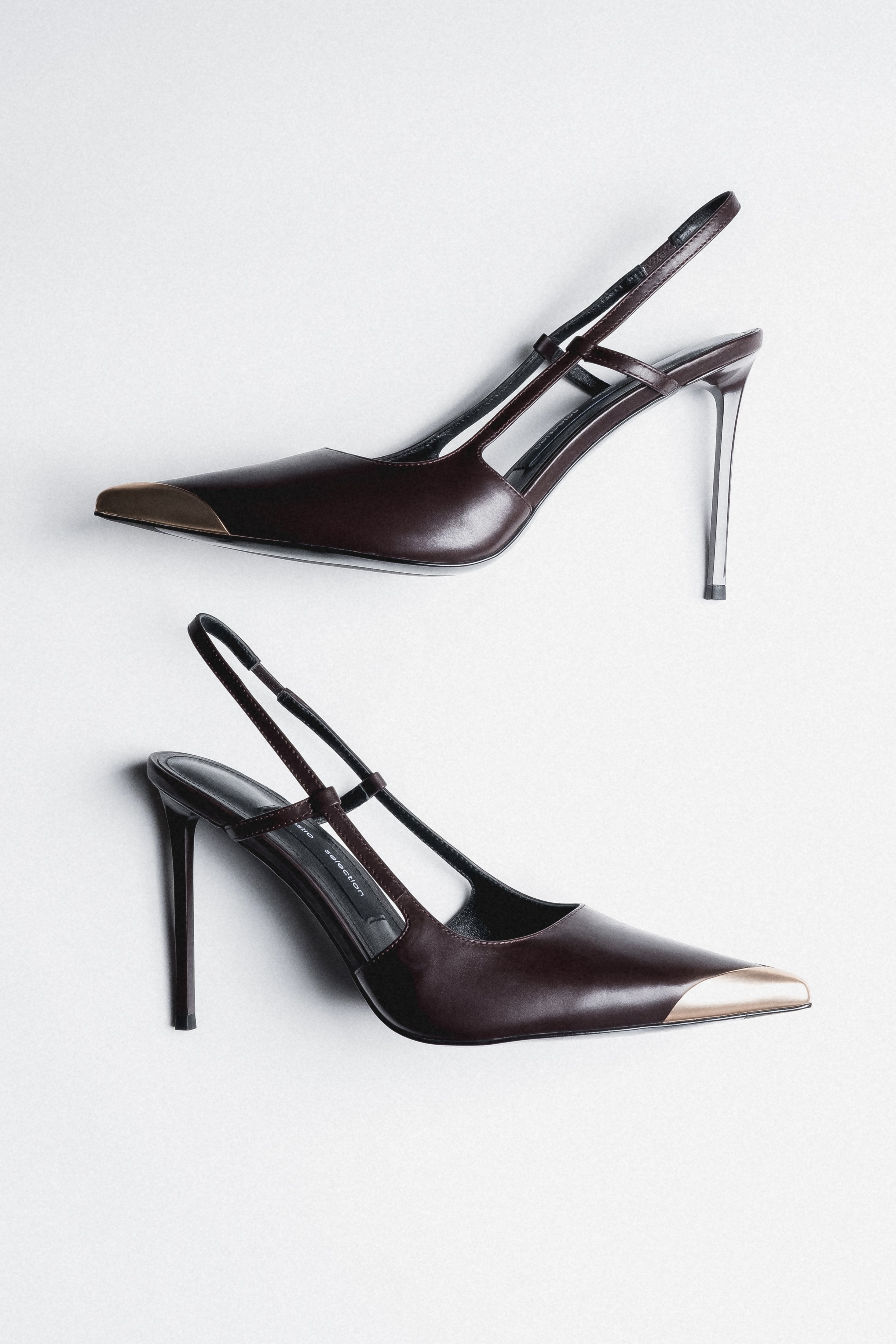 Side view of women's dark brown leather slingback stilettos with gold pointed toe