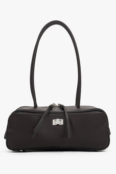 Dark brown natural leather shoulder baguette bag. Slim silhouette and decorative pull tabs at the zippers.
