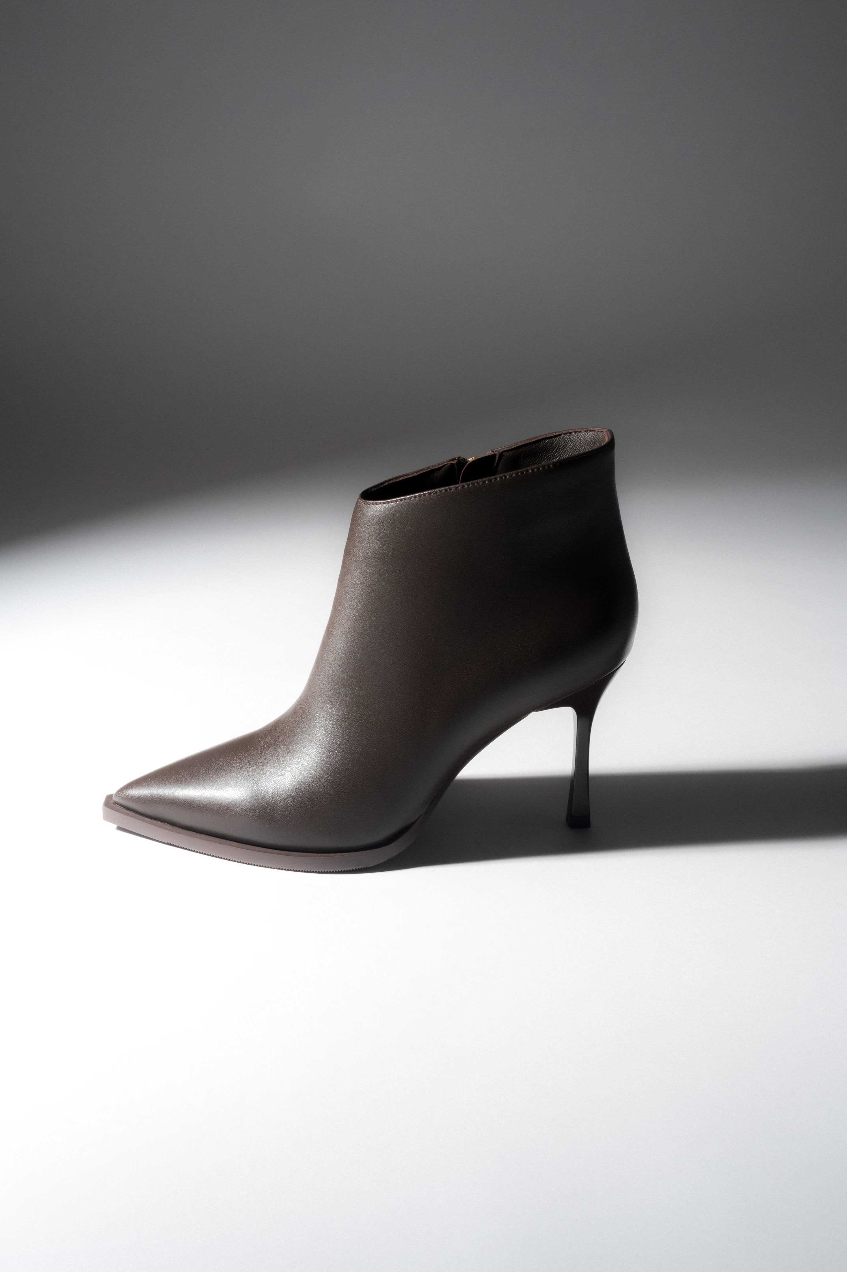 Low dark brown women’s high-heeled ankle boots in genuine leather with a pointed toe.
