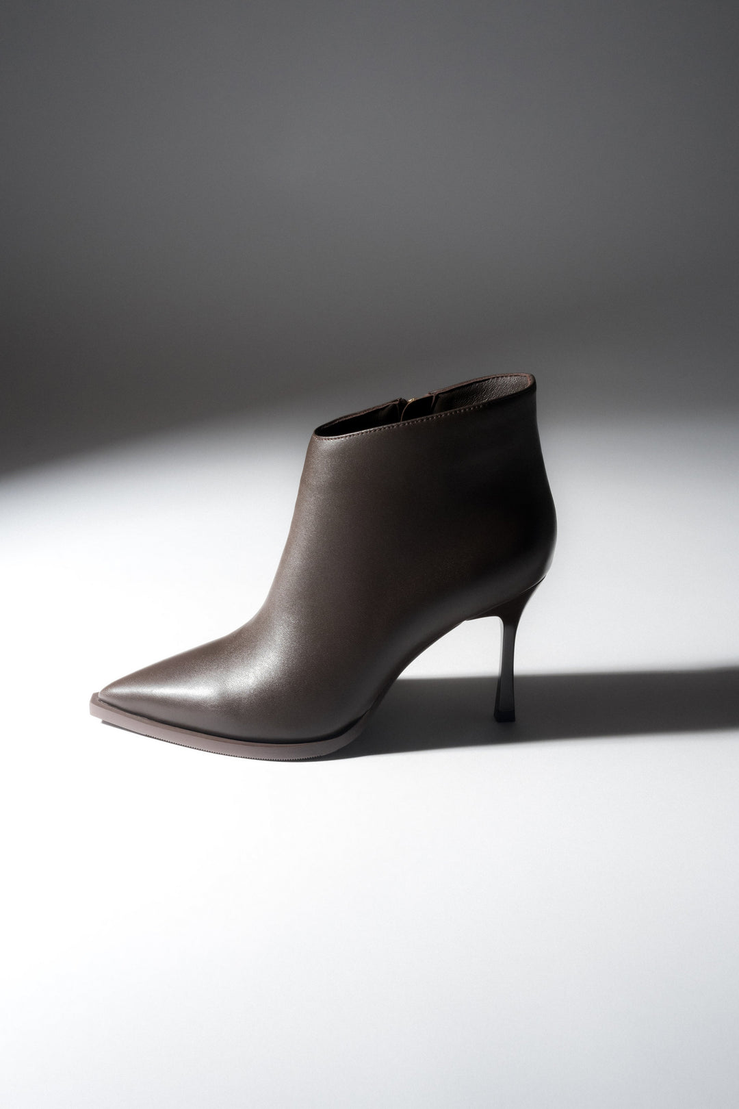 Low dark brown women’s high-heeled ankle boots in genuine leather with a pointed toe.