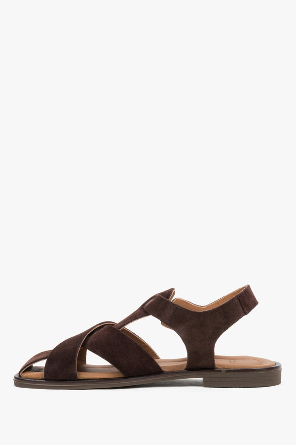 Dark brown women’s natural suede sandals with crisscross straps and a buckle.