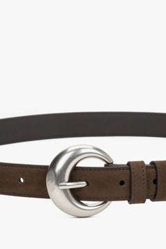 Close-up of the rounded silver buckle on a brown belt.