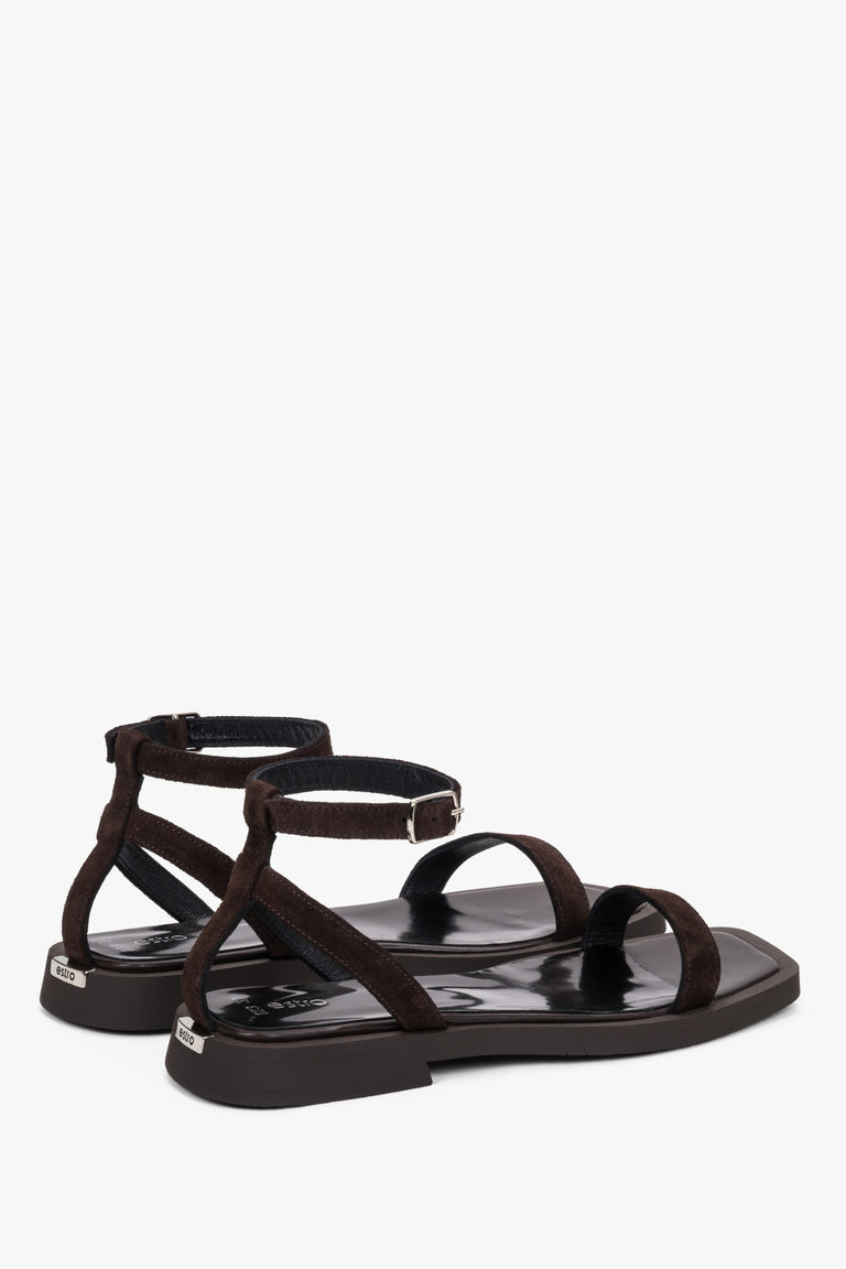 Side view of women’s dark brown flat sandals with delicate thin straps.