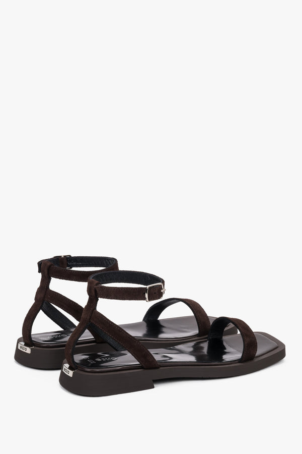 Side view of women’s dark brown flat sandals with delicate thin straps.