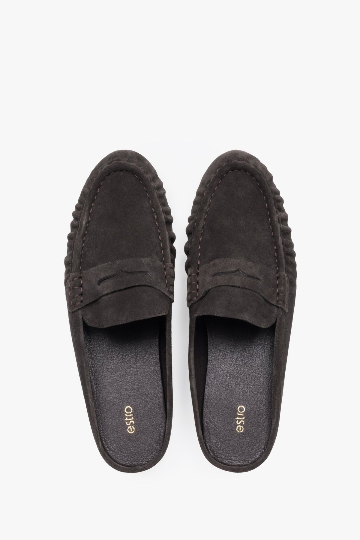 A pair of mules displayed to highlight the loafer-style closed front with a decorative cross strap and a sleek, dark-colored insole.