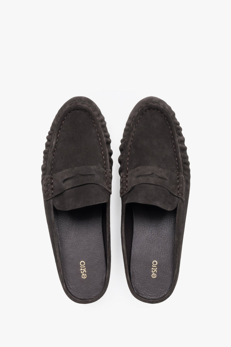 A pair of mules displayed to highlight the loafer-style closed front with a decorative cross strap and a sleek, dark-colored insole.