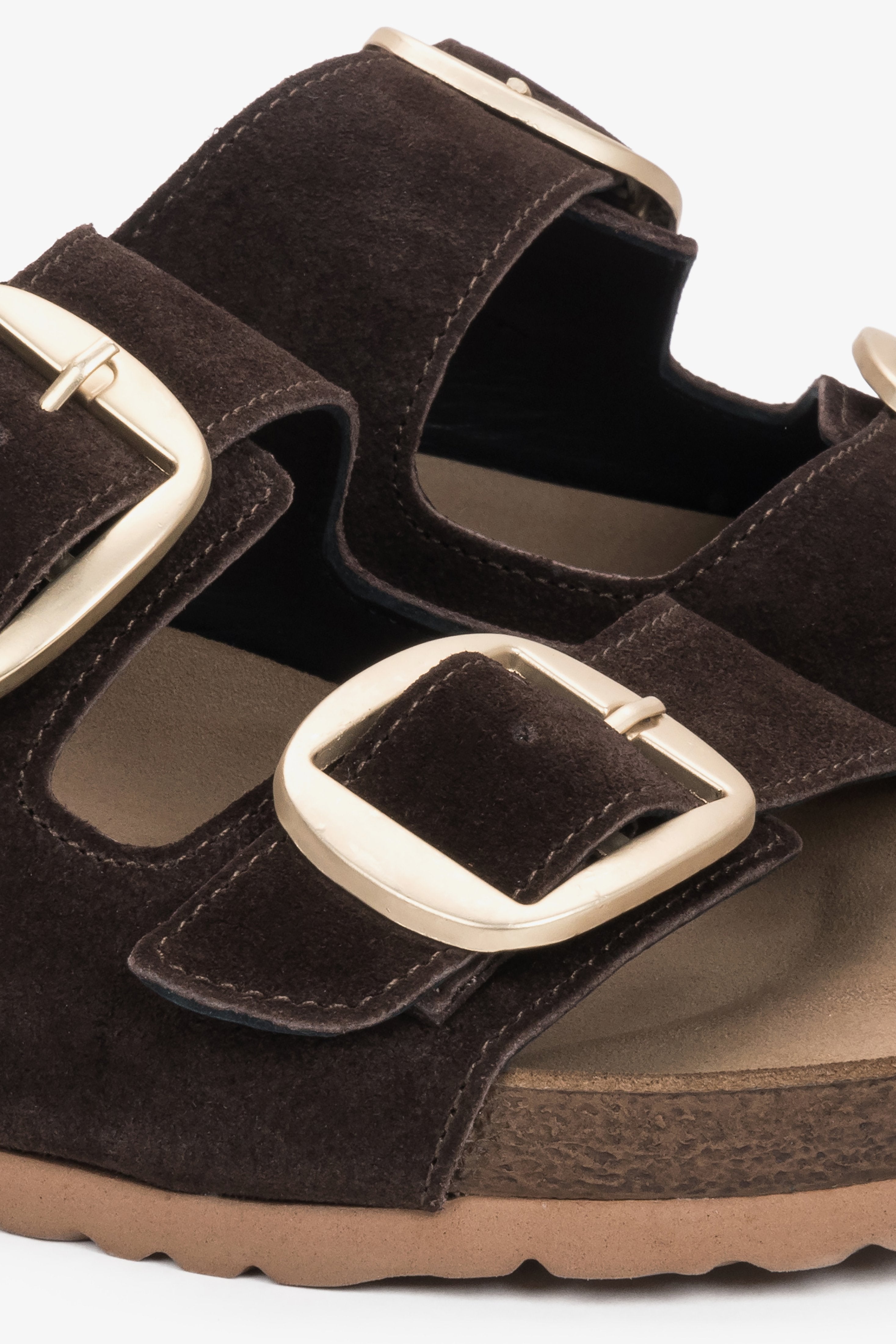 A close-up shot of the upper displaying the gleaming, adjustable gold buckles and the rich, matte texture of the dark brown velour.