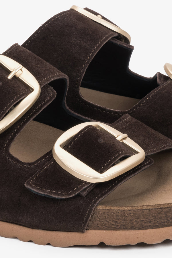 A close-up shot of the upper displaying the gleaming, adjustable gold buckles and the rich, matte texture of the dark brown velour.