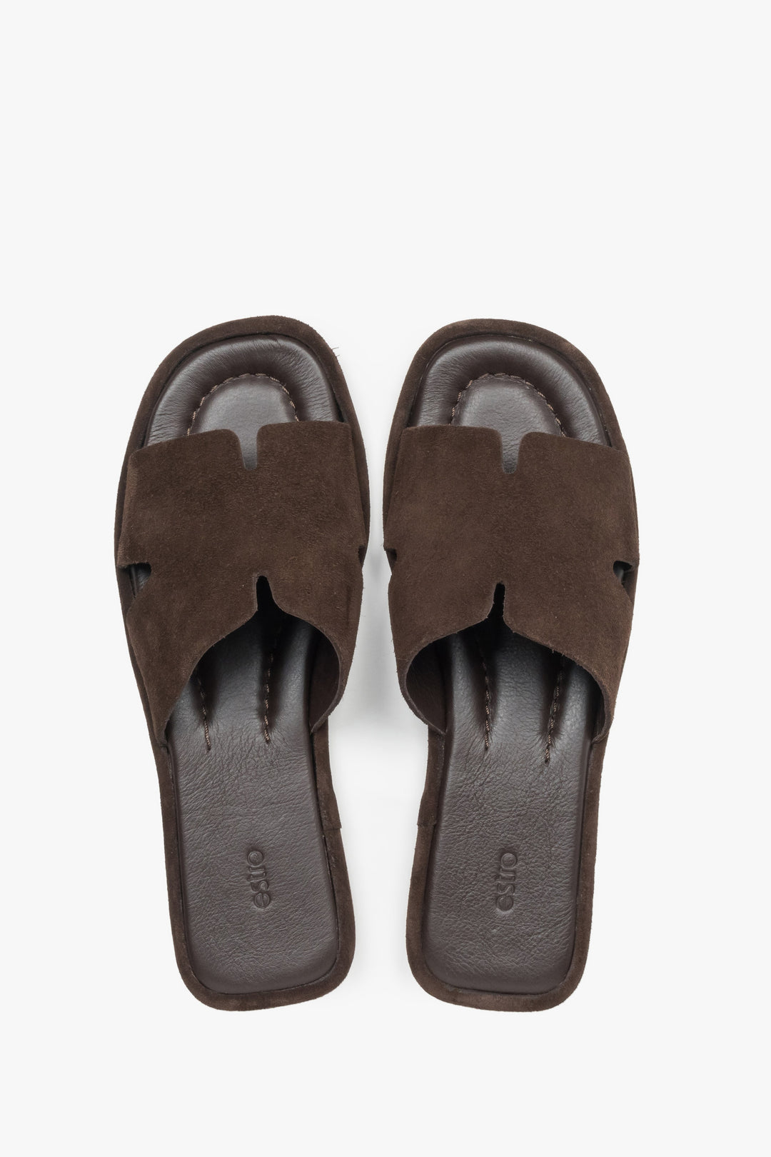 View of a pair of shoes featuring a closed toe with elegant cut-out details and a smooth leather insole finished with a subtle brand logo.