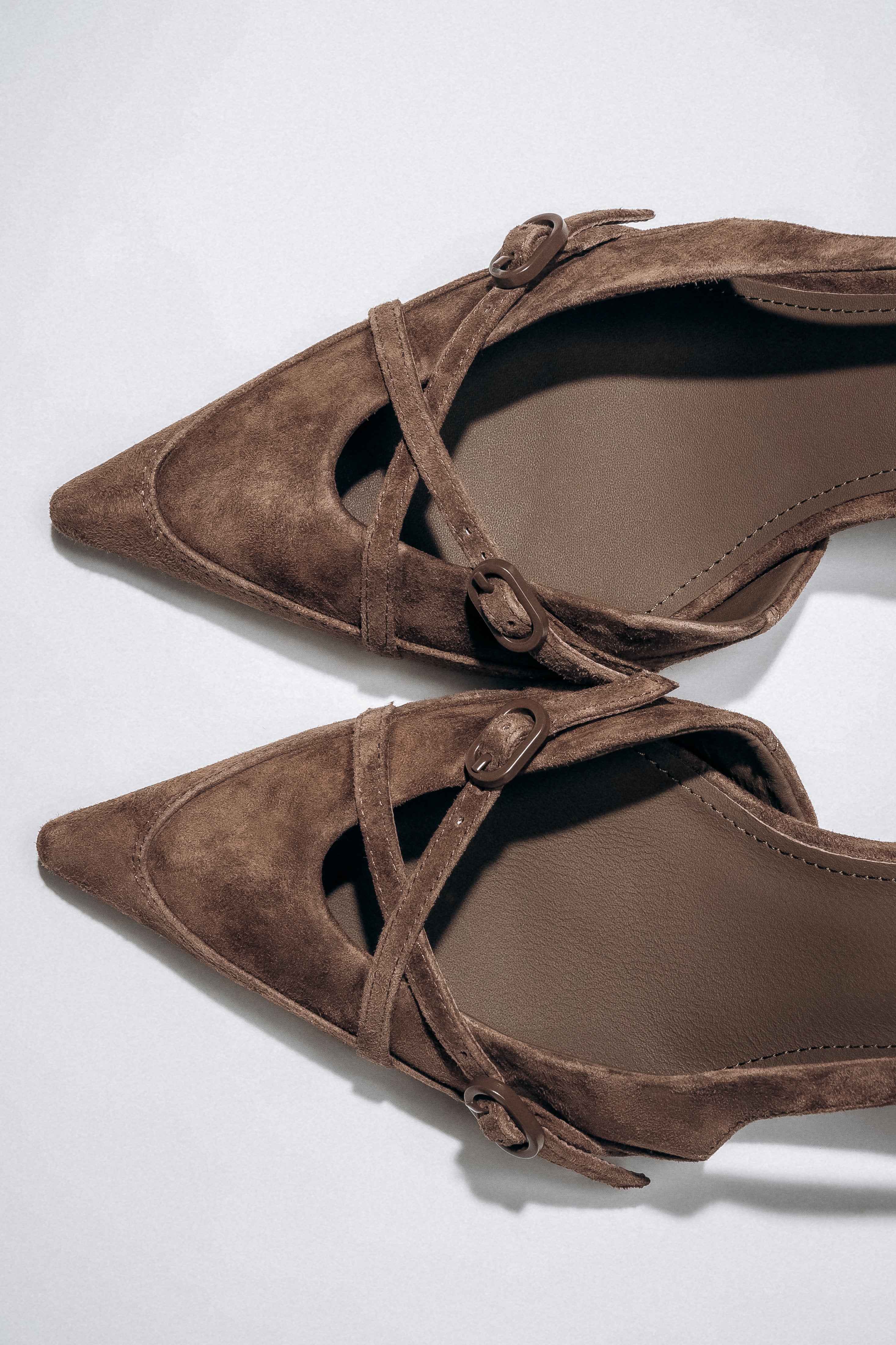 Detail view of crossing straps on dark brown velour slingback heels