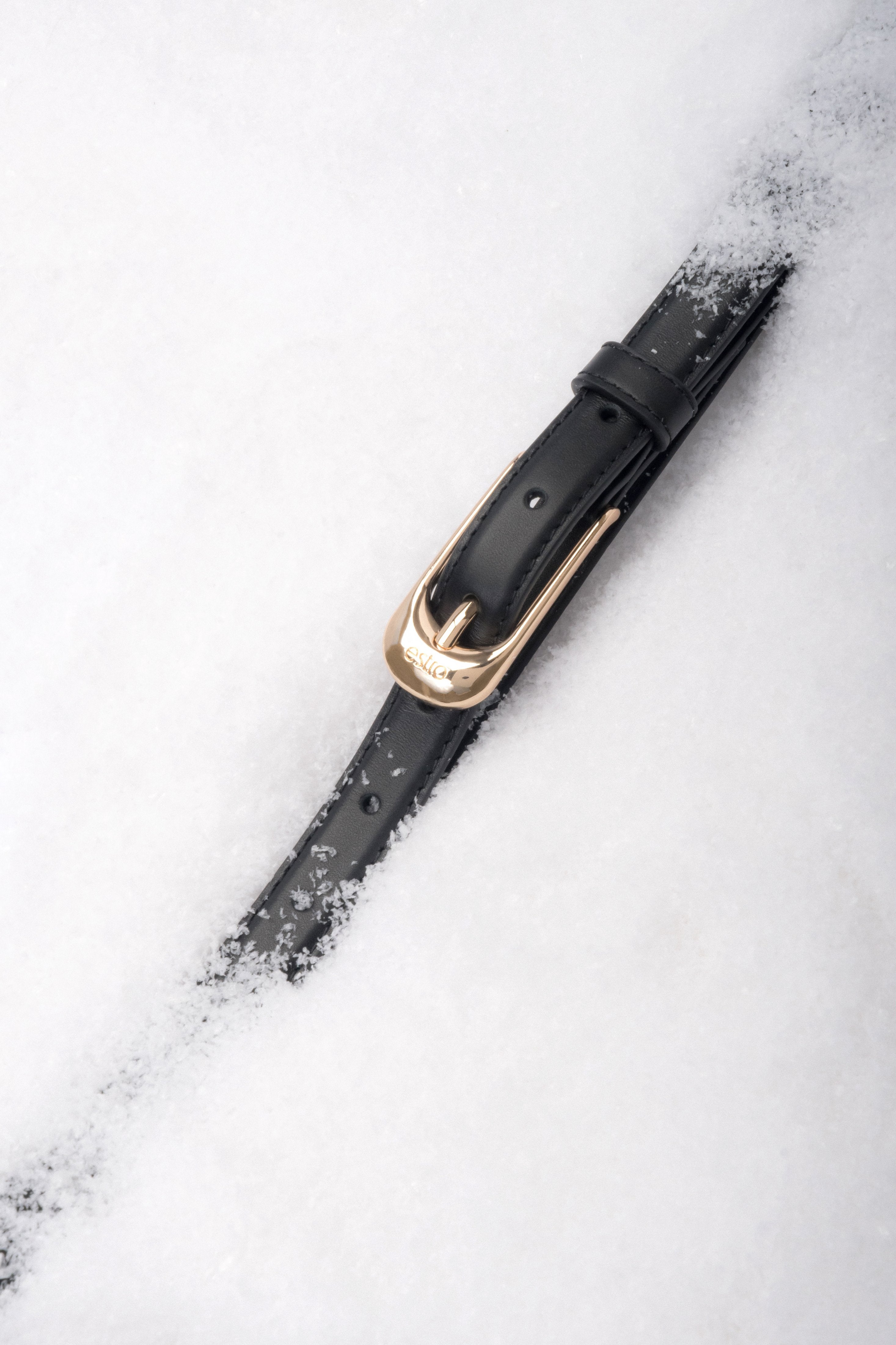 Black elegant women’s belt made of natural leather with gold-tone hardware.