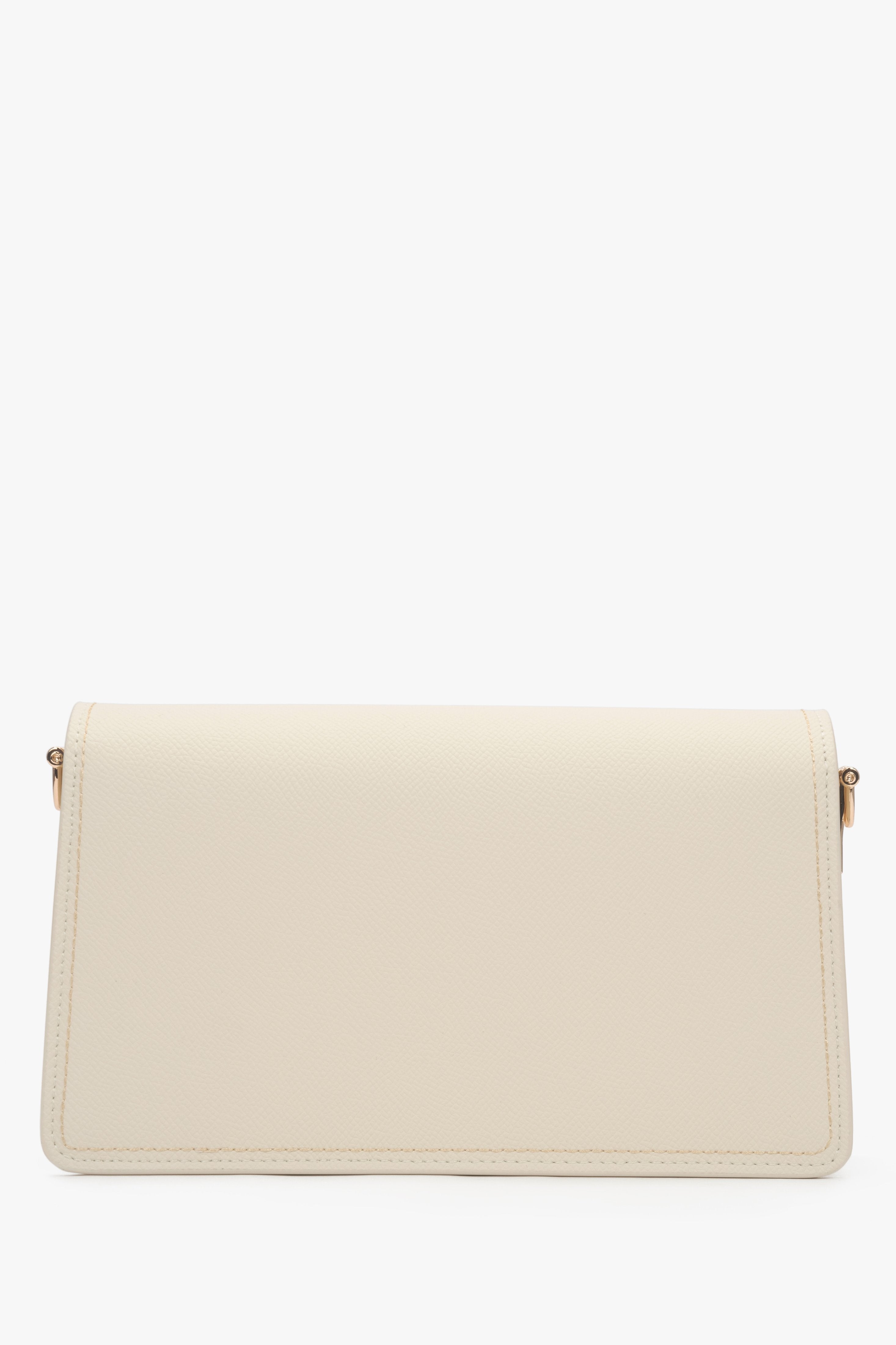 Close-up of the gold-tone snap closure on a milky beige natural leather bag.