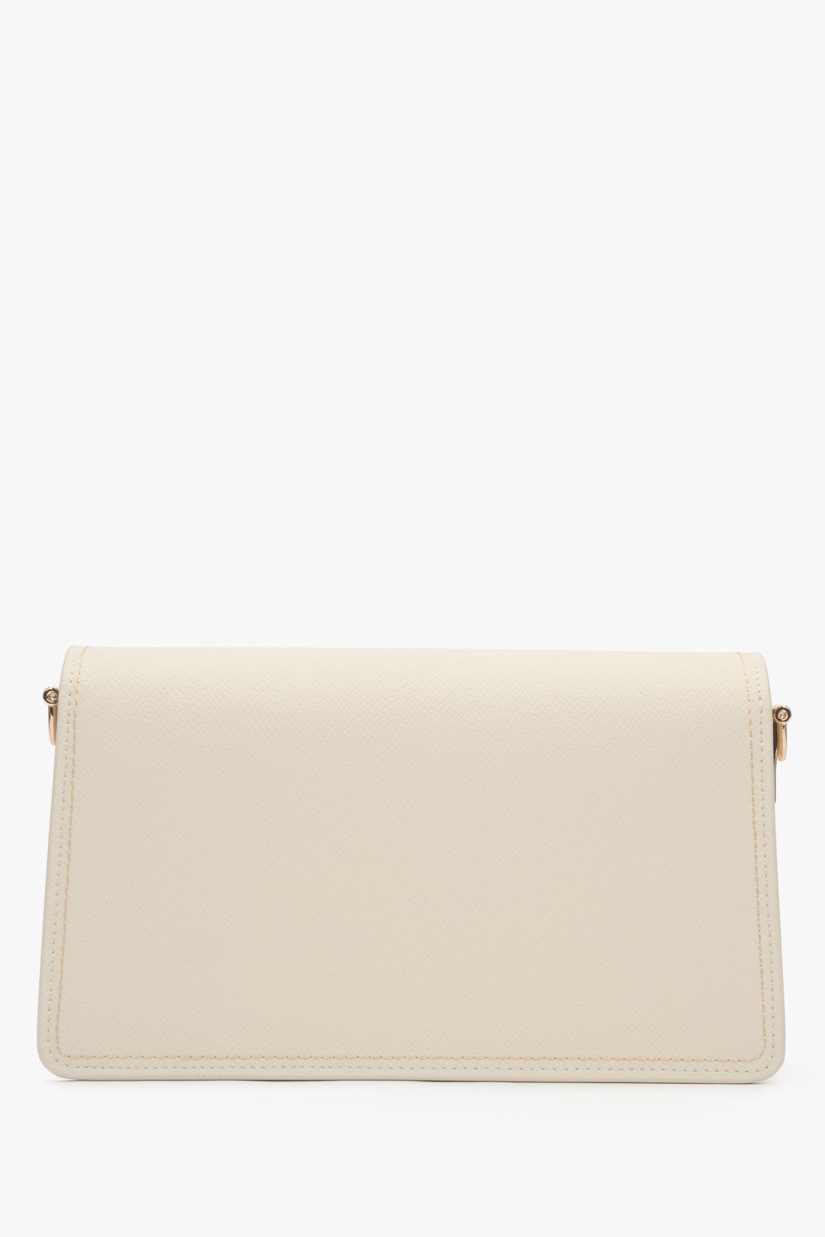 Close-up of the gold-tone snap closure on a milky beige natural leather bag.