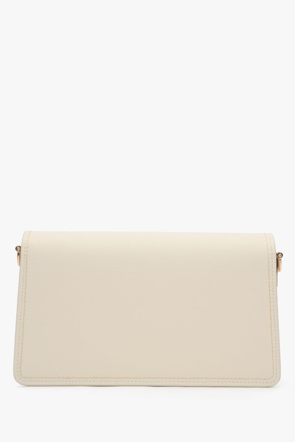 Close-up of the gold-tone snap closure on a milky beige natural leather bag.