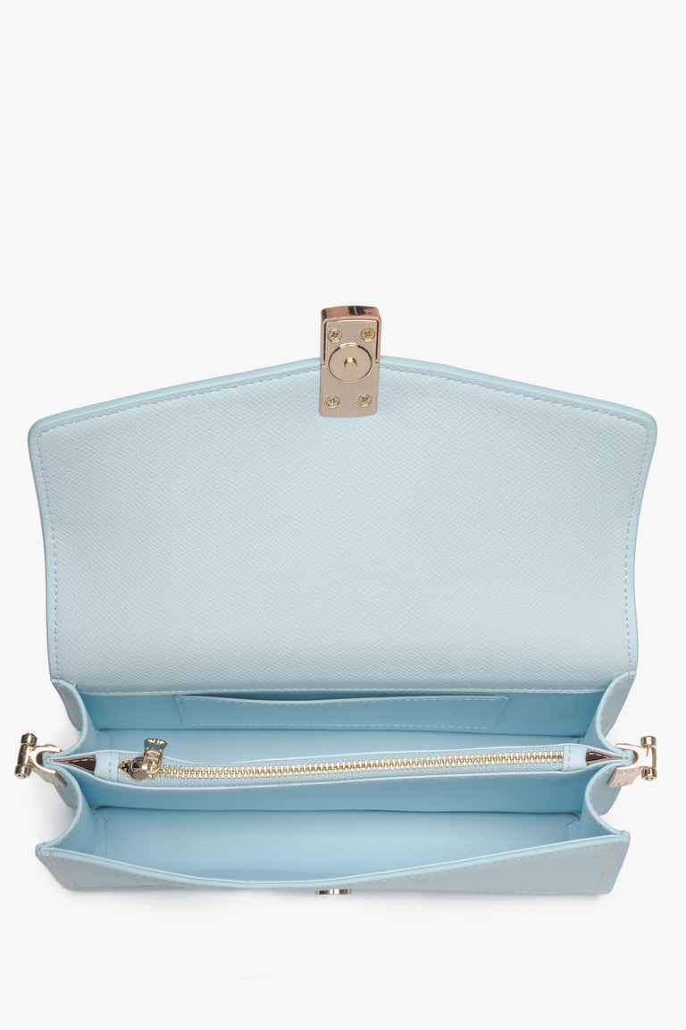 Close-up of the gold-tone snap closure on a light blue natural leather bag.