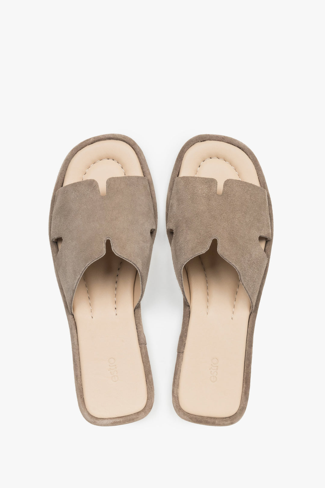 View of a pair of shoes featuring a closed front with elegant cut-outs and a smooth leather insole finished with a subtle brand logo.