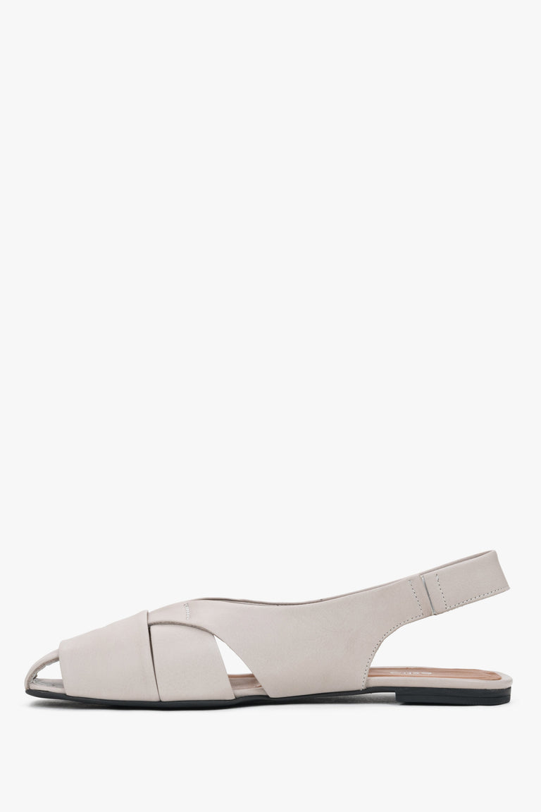 Profile of grey leather sandals with open heel and flat sole.
