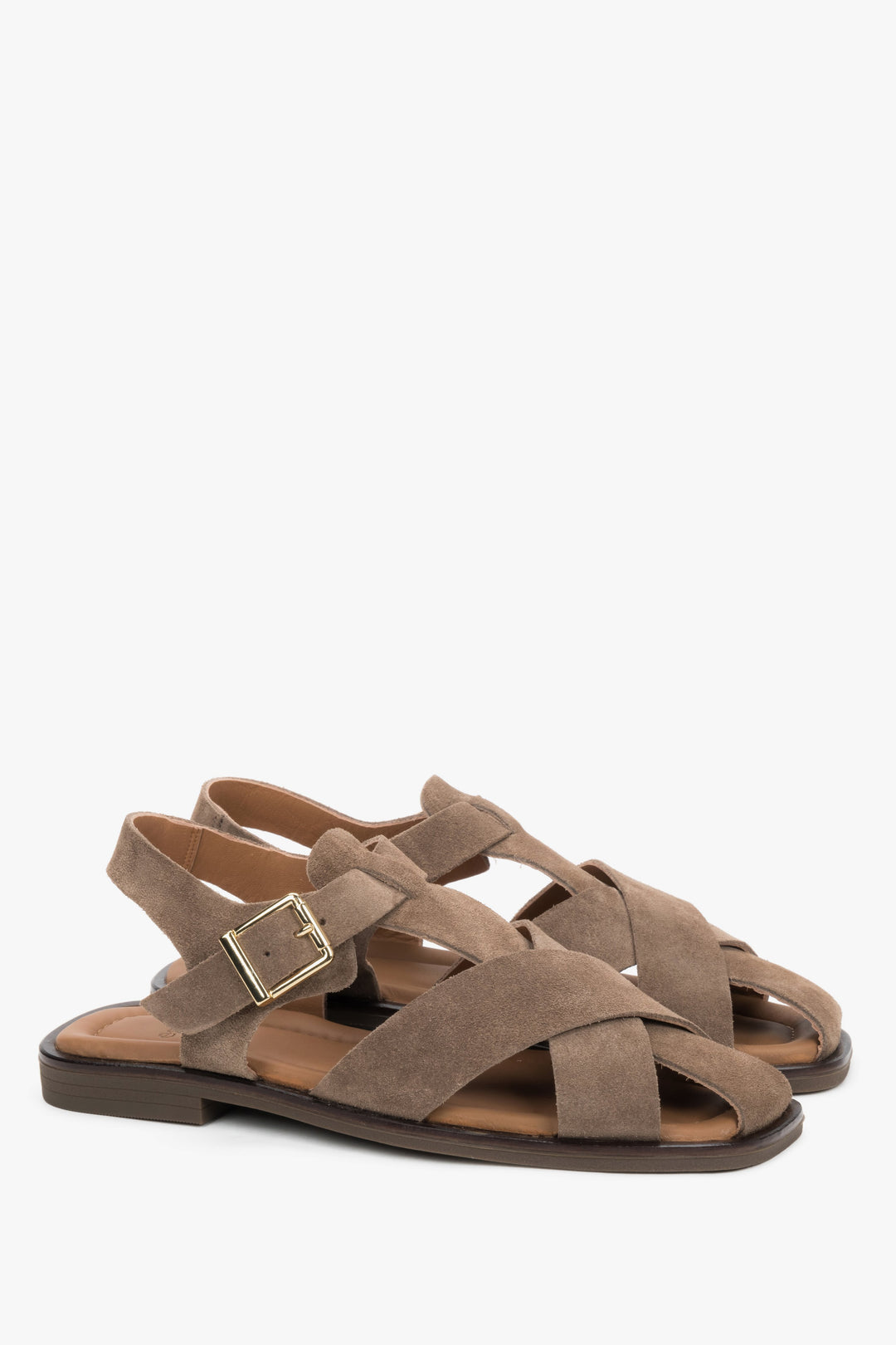 Grey women’s natural suede sandals with crisscross straps and a buckle.