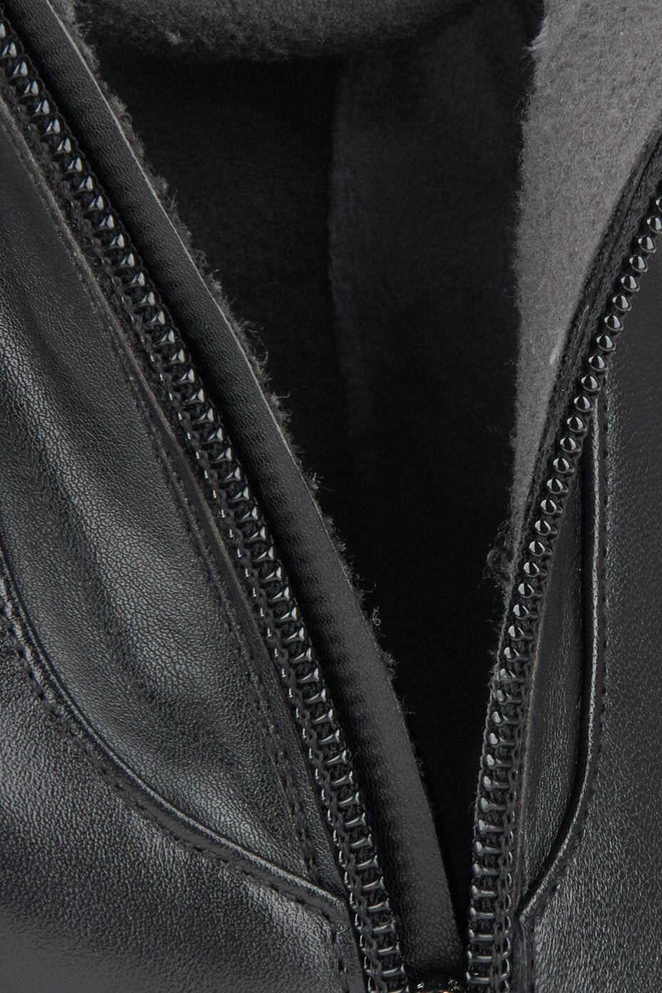 Close-up of a black leather boots with a zipper
