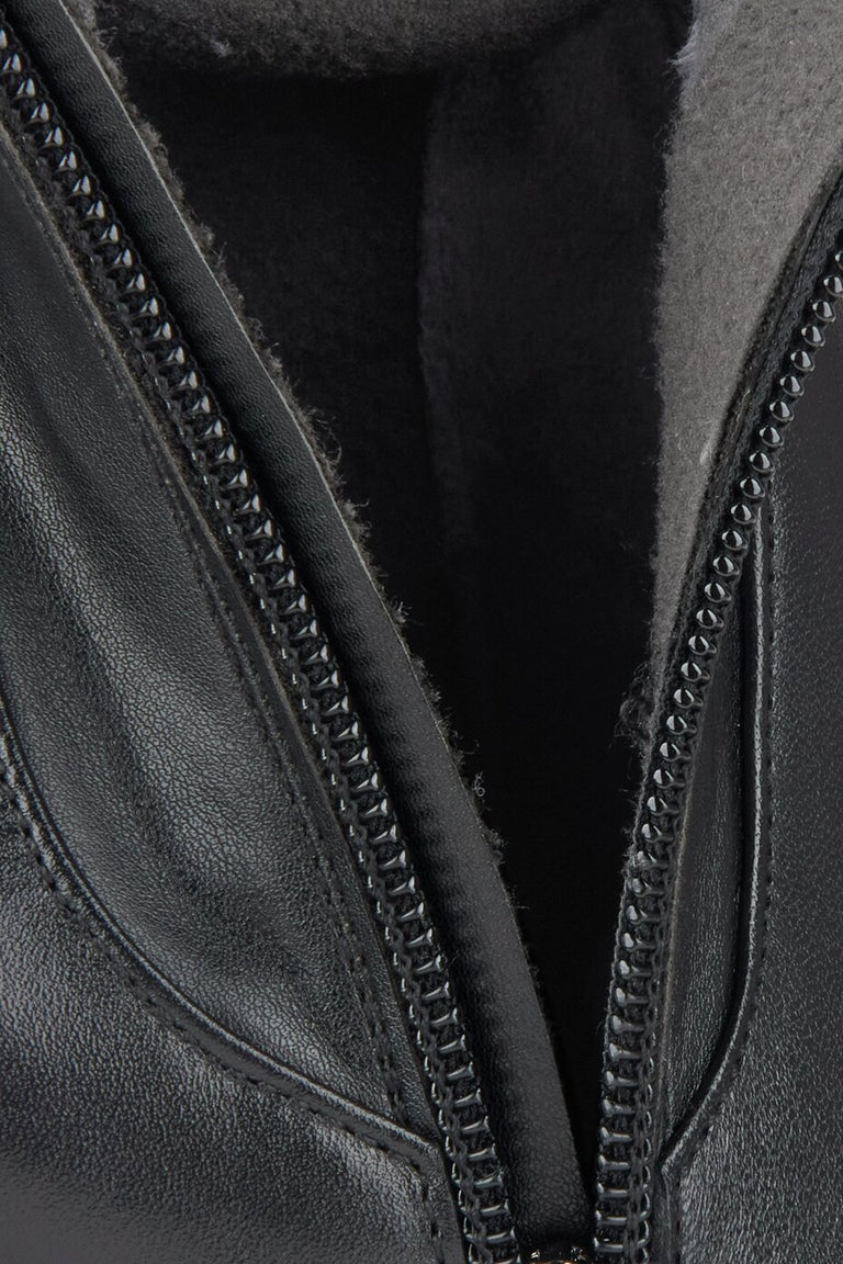 Close-up of a black leather boots with a zipper