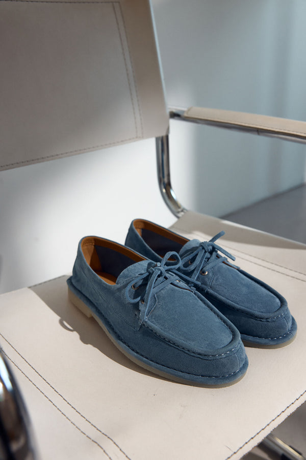 Original blue Estro women's loafers, made of velvet and laced in a nautical style - presentation of the footwear in daylight.