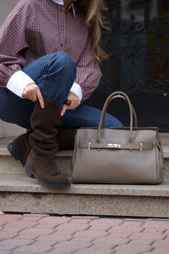 Women's large brown leather bag Estro - angled close-up view showing the top handle construction and gold-tone detail.