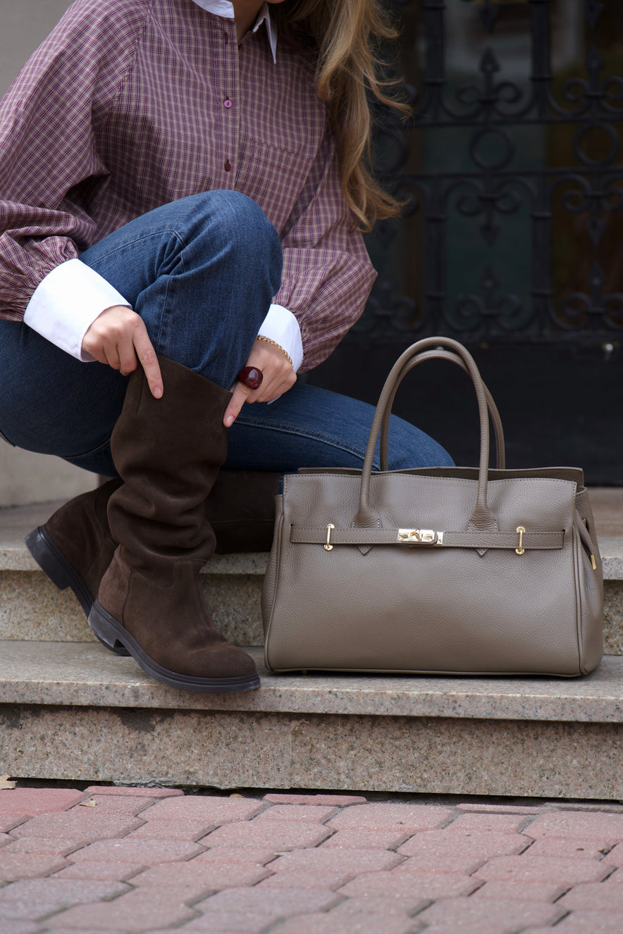 Women's large brown leather bag Estro - angled close-up view showing the top handle construction and gold-tone detail.
