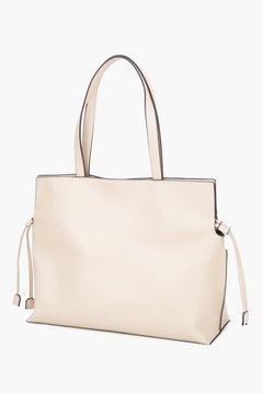 Leather shopper bag with a 14 cm width and loose side ties, showcasing the softness and refined texture of smooth genuine leather - milky-beige colour.