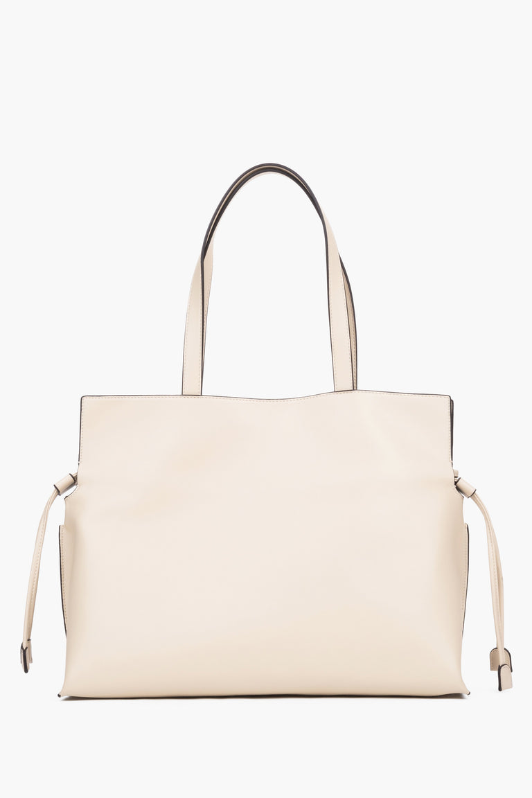Close-up of a beige bag featuring adjustable side drawstrings that elegantly gather the sides and transform the silhouette of the bag.