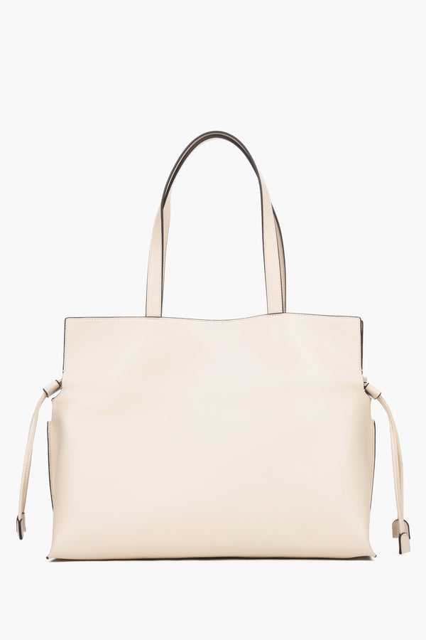 Close-up of a beige bag featuring adjustable side drawstrings that elegantly gather the sides and transform the silhouette of the bag.