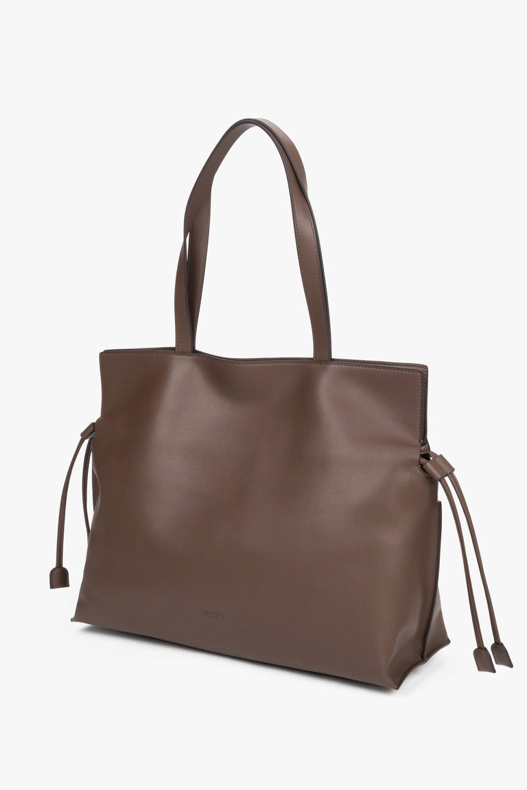 Leather shopper bag with a 14 cm width and loose side ties, showcasing the softness and refined texture of smooth genuine leather.