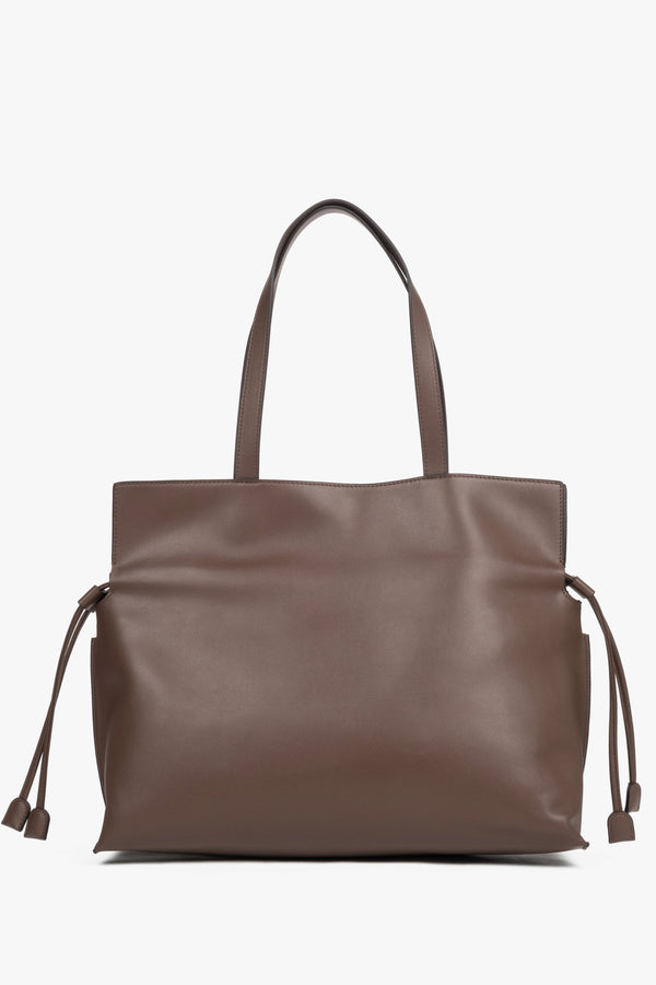 Close-up of a brown bag featuring adjustable side drawstrings that elegantly gather the sides and transform the silhouette of the bag.