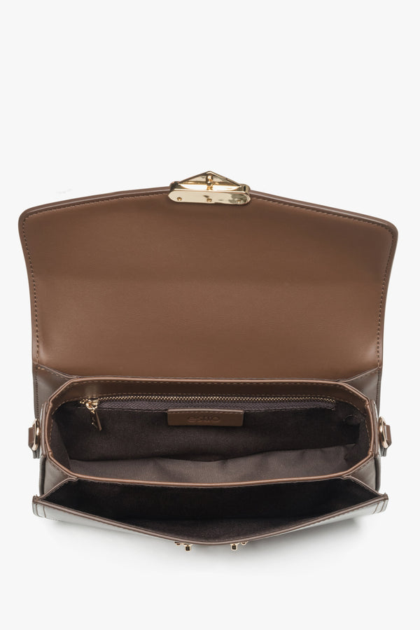 Saddle brown leather handbag featuring a gold-tone snap closure and textile lining.