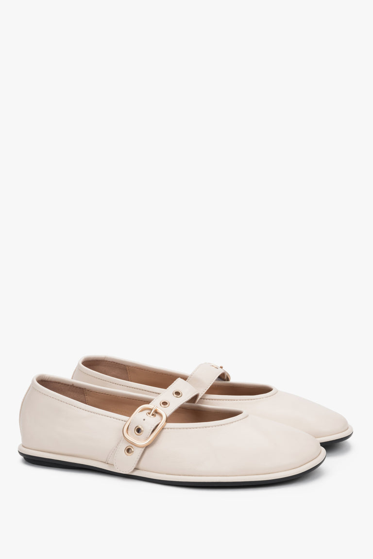A profile shot of the beige leather ballet flats highlighting the slim, flat rubber sole and the elegant positioning of the adjustable ankle strap.