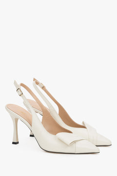 Light beige leather Estro slingback pumps on a high stiletto heel, featuring a deep vamp, a geometric toe detail, and a slim strap around the heel.