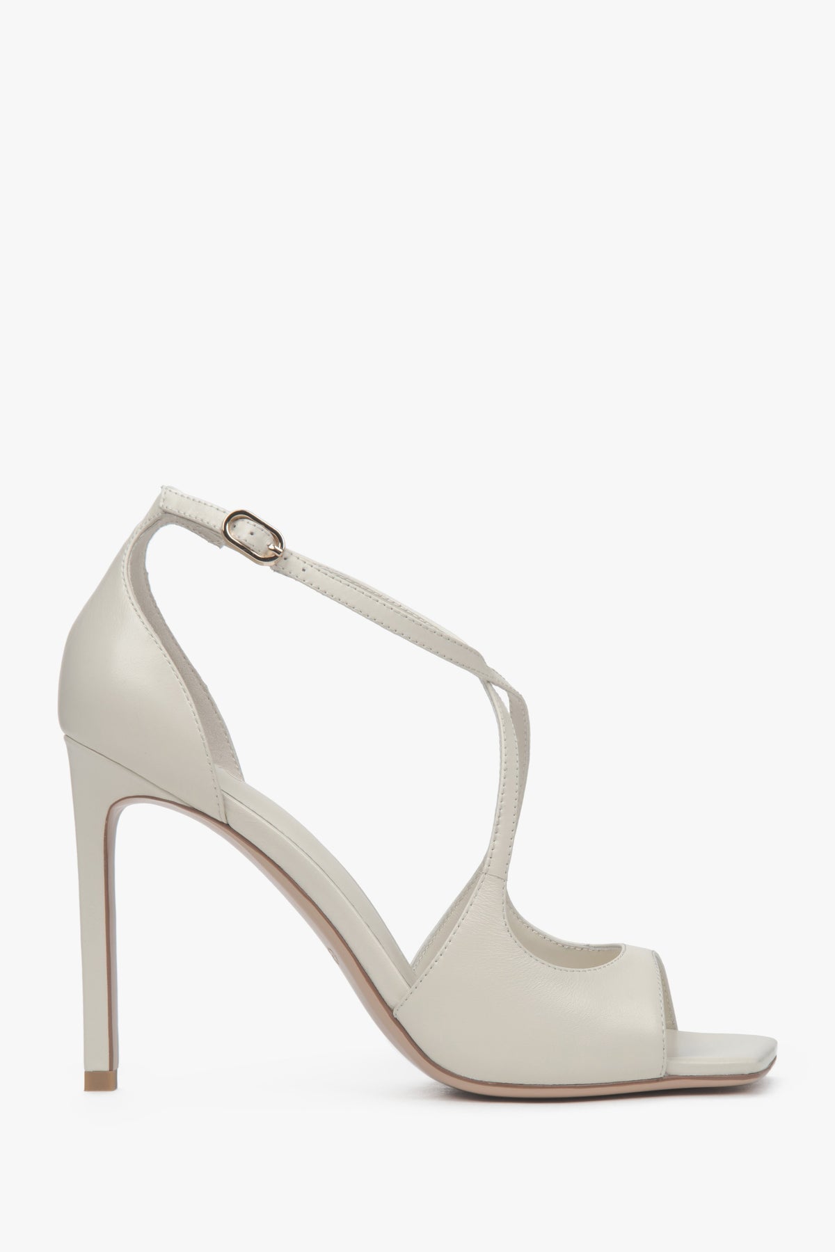 Women’s light beige stiletto sandals with decorative fastening.