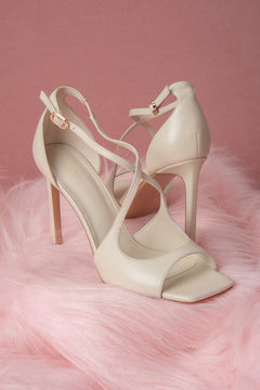 Women’s light beige stiletto sandals with decorative fastening.