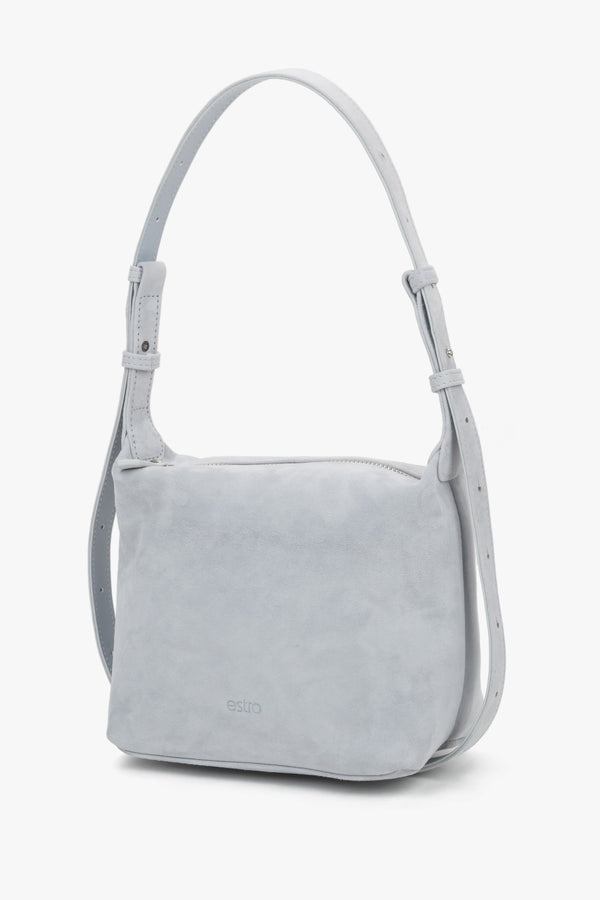 Estro light blue suede women's shoulder bag, showcasing a minimalist front with a subtle brand logo and a soft, structured silhouette.