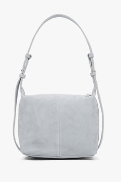 Light blue natural suede handbag, showing a smooth back with a vertical center seam and aesthetically finished strap attachments.