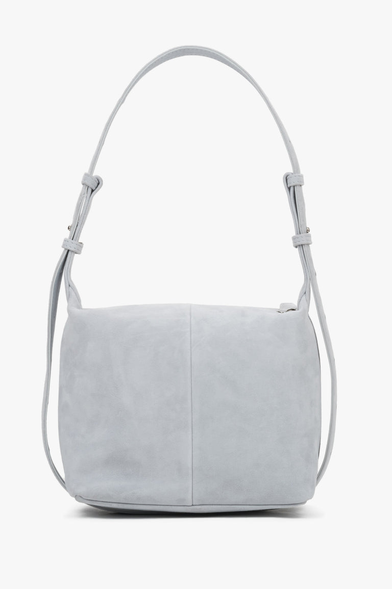 Light blue natural suede handbag, showing a smooth back with a vertical center seam and aesthetically finished strap attachments.