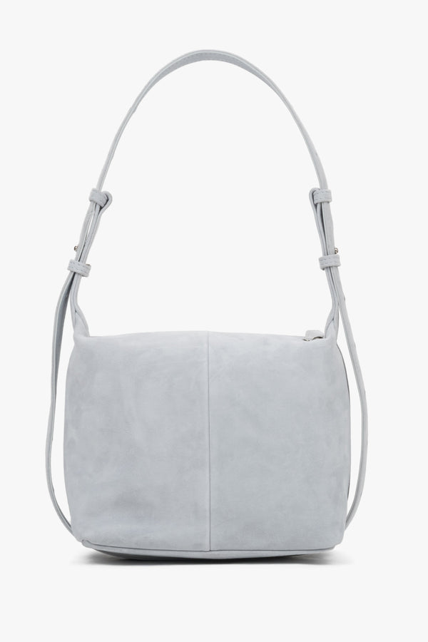 Light blue natural suede handbag, showing a smooth back with a vertical center seam and aesthetically finished strap attachments.