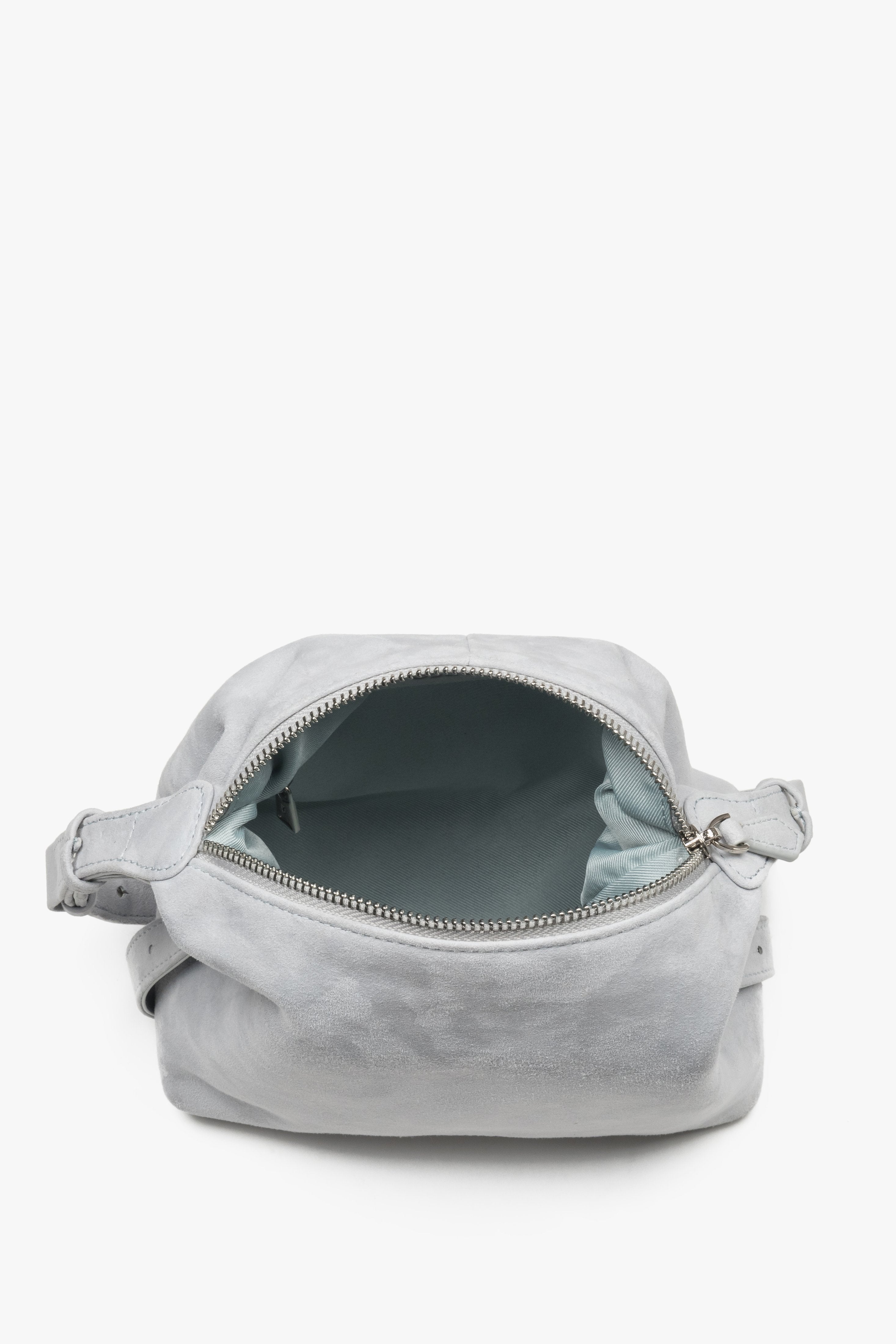 Wide-open main compartment with a zipper closure, showcasing a light-colored lining, functional internal pockets, and silver zipper details.