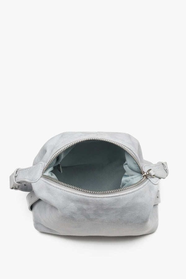 Wide-open main compartment with a zipper closure, showcasing a light-colored lining, functional internal pockets, and silver zipper details.
