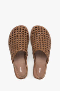 Women's flat leather sandals with an intricate openwork weave.