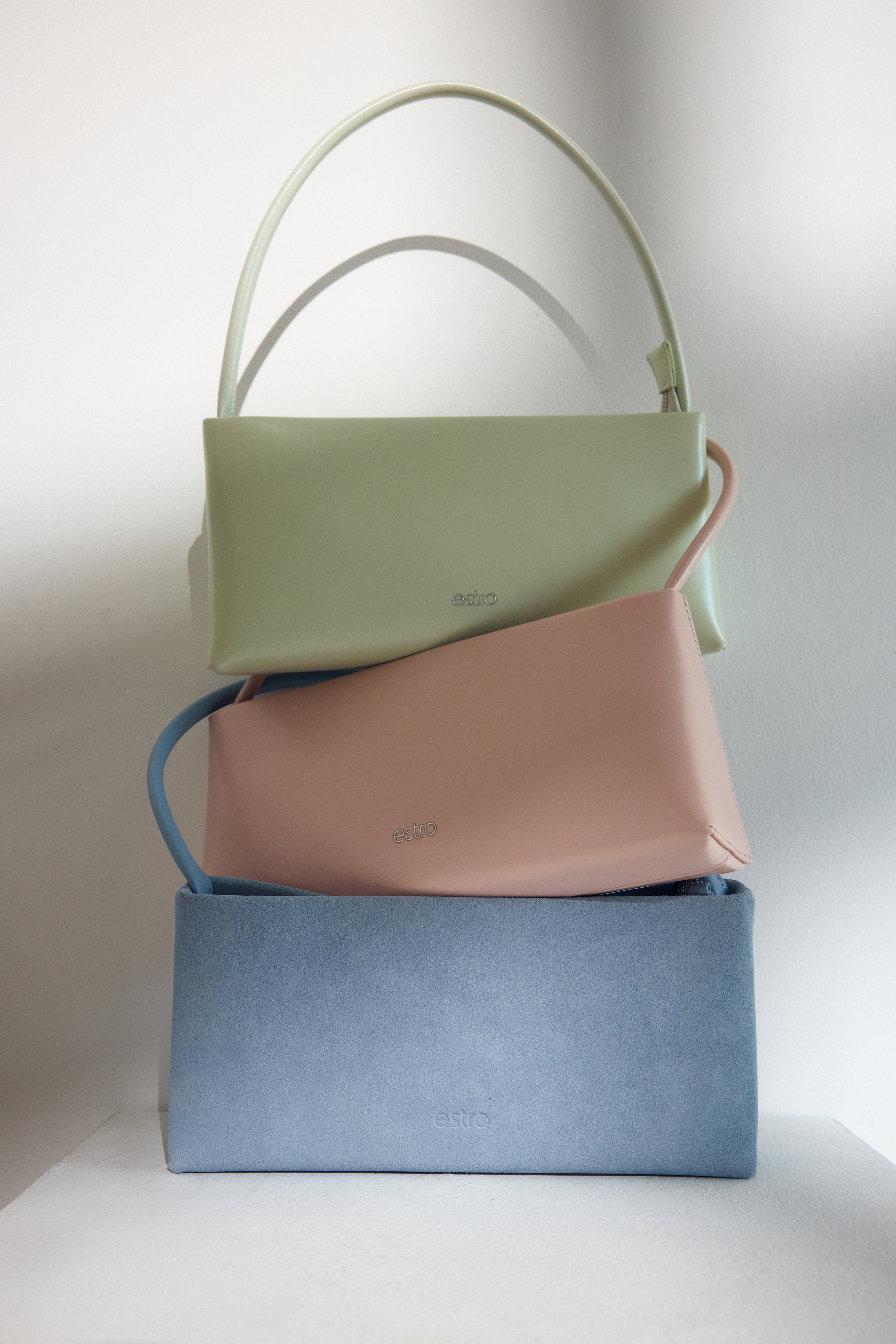 Chic light pink baguette bag with a sleek leather finish and silver zip.
